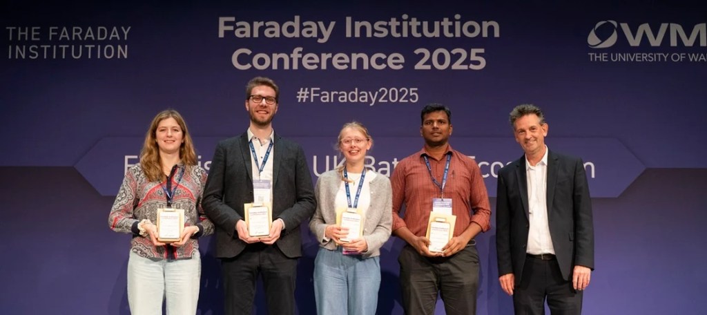 The four FI conference poster winners holding their awards in front of a hoarding saying FI conference 2025. Isabel Antony is on the left, Martin Freer  FI CEO is on the right.